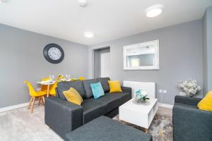 a living room with a black couch and yellow pillows at Elegant Flat Near Stonehenge, Amesbury Town Centre Smart TVs Netflix FREE PARKING in Amesbury