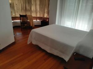 A bed or beds in a room at Pensión Vista Alegre