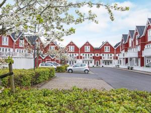 een auto geparkeerd voor een rij rode en witte gebouwen bij Holiday home Gråsten LXVIII in Gråsten