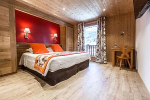 Schlafzimmer mit einem großen Bett mit einem roten Kopfteil in der Unterkunft Hotel Les Bruyères in Morzine