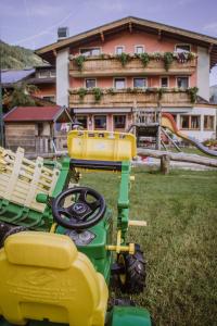 un tracteur vert et jaune garé dans une cour dans l'établissement Gasthof Haidbach, à Mittersill