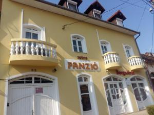 Um edifício amarelo com um cartaz de "pampo". em Retro Panzió em Pécs