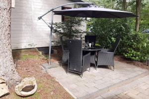 een tafel en stoelen onder een parasol op een patio bij Chalet "de Hazelnoot" te Diever in Diever