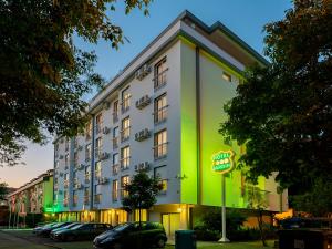 un grande edificio con un cartello verde davanti di Hotel Jardim ad Aveiro