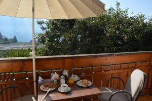 una mesa con una sombrilla y comida en ella en Apartment Pyrus, en Tirolo