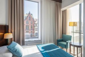 Pokój hotelowy z łóżkiem, krzesłem i oknem w obiekcie Europeum Hotel we Wrocławiu