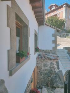 un bâtiment blanc avec un panneau sur son côté dans l'établissement Casa Rural el Enebral en Potes Picos de Euopa, à Colio