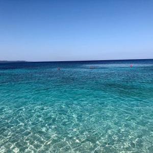 une grande étendue d'eau bleue avec des gens dans l'océan dans l'établissement Villas Ermali, à Ksamil