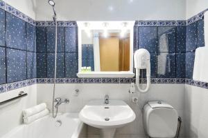 a bathroom with a sink and a toilet and a mirror at Art Hotel Academy in Dnipro