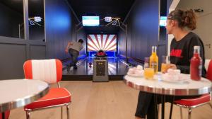 um homem a jogar bowling numa pista de bowling em Plan B Hotel - Living Chamonix em Chamonix-Mont-Blanc