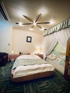 - une chambre avec un lit et un ventilateur de plafond dans l'établissement Hotel Sagano (Adult only), à Kyoto