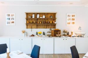 - une cuisine avec des placards blancs et des chaises bleues dans l'établissement Landhotel Potsdam, à Potsdam