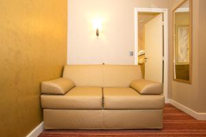 a couch in a room with a light on the wall at Hotel Bellevue Saint-Lazare in Paris