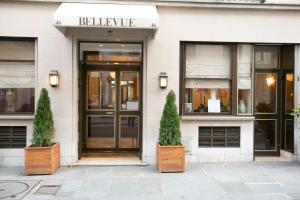 a building with two potted trees in front of it at Hotel Bellevue Saint-Lazare in Paris