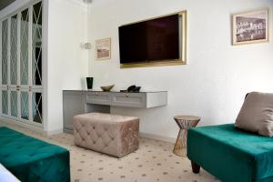 a living room with a tv and a couch at Villa Giardino Heritage Boutique Hotel Bol in Bol