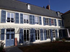 a white house with blue shutters on it at Les Pierres Bleues in Bar-sur-Aube