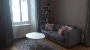 a living room with a couch and a table at Les Pierres Bleues in Bar-sur-Aube