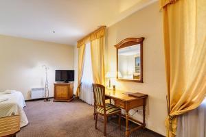 a hotel room with a desk and a mirror at Art Hotel Academy in Dnipro