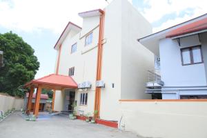 een wit gebouw met een rood dak bij Hotel Cedar in Jaffna