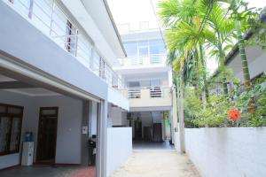 een lege hal van een gebouw met palmbomen bij Hotel Cedar in Jaffna