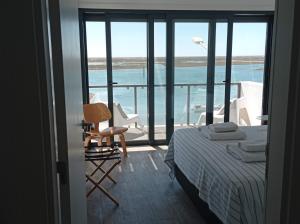 um quarto com uma cama e vista para o oceano em Flamingo Beach House em Santa Luzia