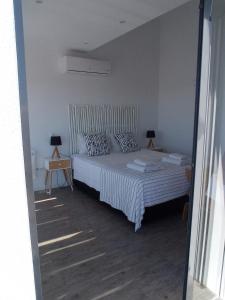 um quarto com uma cama e 2 candeeiros nas mesas em Flamingo Beach House em Santa Luzia