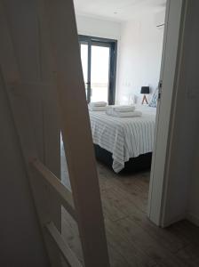 um quarto com uma cama com um edredão branco em Flamingo Beach House em Santa Luzia