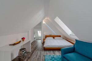 ein Schlafzimmer mit einem Bett und einem blauen Sofa in der Unterkunft Smile Apartments zum Goldenen Strauß in Dürnstein