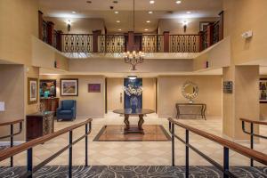 a lobby of a hotel with a table and a staircase at Clarion Collection Hotel Arlington Court Suites in Arlington