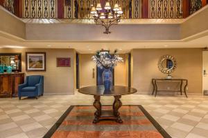 a lobby with a table with a vase of flowers on it at Clarion Collection Hotel Arlington Court Suites in Arlington