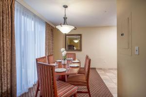 a dining room with a table and chairs and a window at Clarion Collection Hotel Arlington Court Suites in Arlington