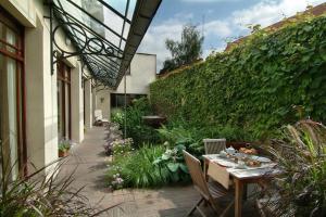 un patio con tavolo e sedie in giardino di Flanders Hotel a Bruges