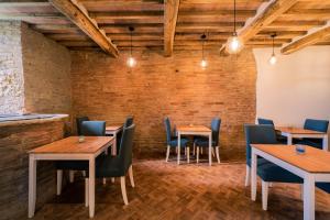 un restaurante con mesas y sillas de madera y una pared de ladrillo en Il giardino di Pantaneto Residenza D'Epoca, en Siena