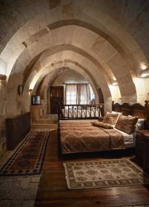 een slaapkamer met een groot bed in een stenen kamer bij Melis Cave Hotel in Urgup