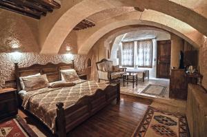 een slaapkamer met een groot bed in een stenen kamer bij Melis Cave Hotel in Urgup