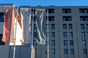 un grupo de banderas colgando frente a un edificio en Nash Airport Hotel, en Ginebra