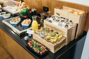 ein Buffet mit Speisen auf einem Tisch mit Obst und Gemüse in der Unterkunft Central Point Hotel Beograd in Belgrad