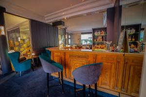 een bar in een restaurant met blauwe stoelen bij Hotel d'Angleterre in Châlons-en-Champagne