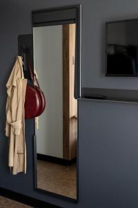 uno specchio davanti a una porta con una borsa e una borsa di B&B HOTEL Poitiers Aéroport a Poitiers