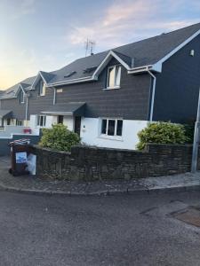 Maison noire et blanche avec un mur en pierre dans l'établissement Feather bed 3 bedroom house, à Kinsale