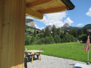 patio ze stołem piknikowym i górami w tle w obiekcie Chalet Dumbria Dolomites w mieście Selva di Val Gardena