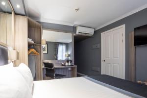 ein Schlafzimmer mit einem Bett und einem Schreibtisch mit einem Stuhl in der Unterkunft Holiday Inn - Glasgow - City Ctr Theatreland, an IHG Hotel in Glasgow