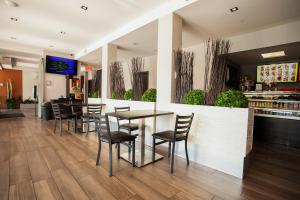 un restaurant avec des chaises, une table et un comptoir dans l'établissement Hotel Newstar Montréal, à Montréal