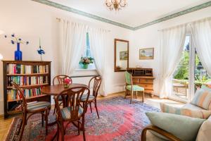 sala de estar con mesa, sillas y sofá en Villa Konstanze, en Velden am Wörthersee