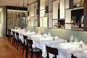 a row of tables in a restaurant with white table cloth at Hotel Löwen am See in Zug