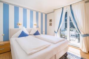 1 dormitorio con 1 cama con rayas azules y blancas en Villa Konstanze, en Velden am Wörthersee