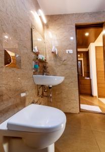 a bathroom with a white toilet and a sink at Aloka Stay Inn in Vellore