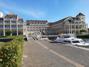 un grand bâtiment avec un bateau amarré dans l'eau dans l'établissement Ferienhaus ˋLichtblickˋ, à Rheinsberg