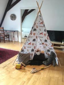 une tente en tipi avec un ours en peluche dans une pièce dans l'établissement Heidelberg Apheartments, à Heidelberg