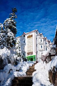 un edificio con nieve en las escaleras delante en VICTOR Hotel Resort & SPA, en Truskavets